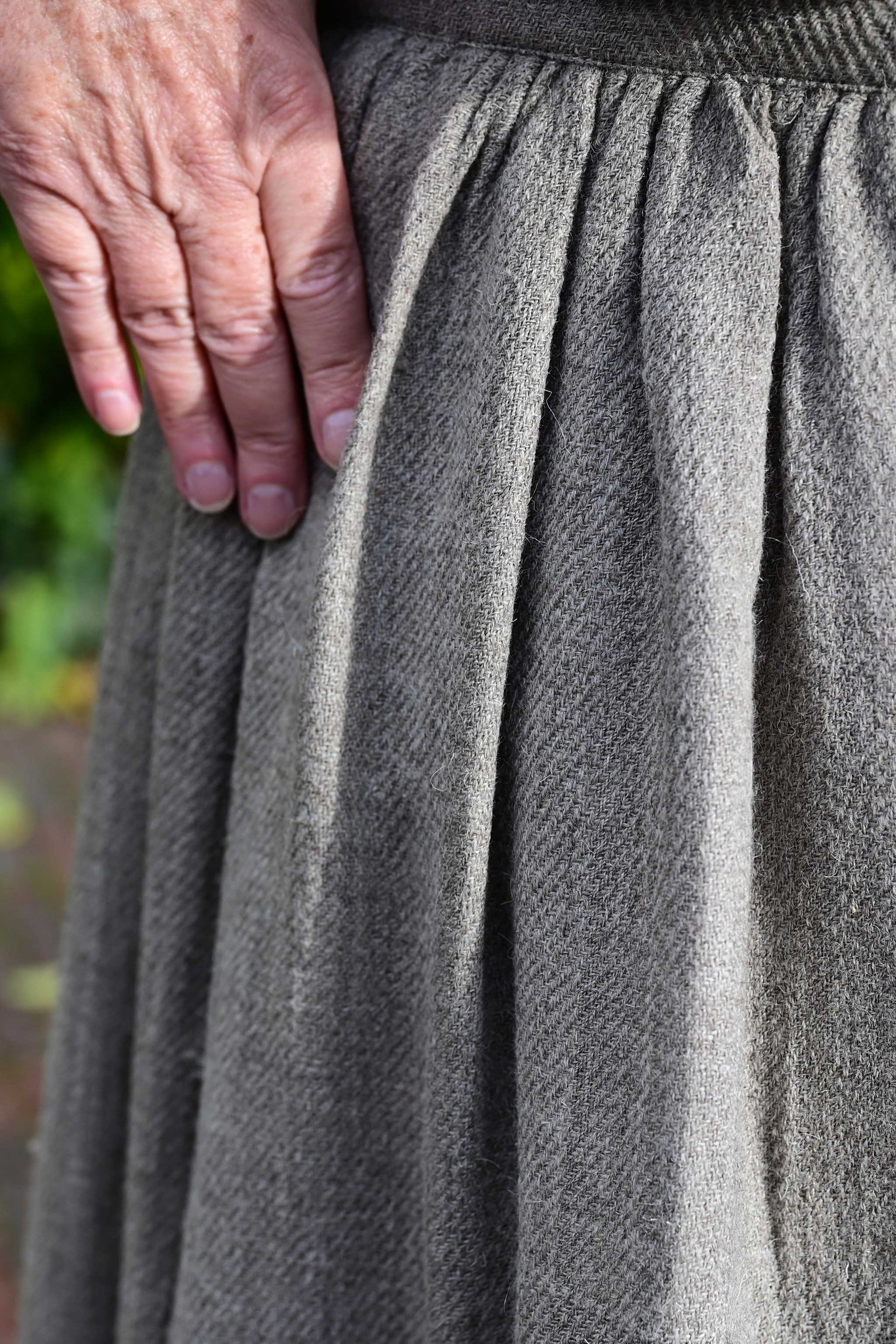 Close up of gathers on the waist of a long gathered skirt made of natural brown Indian wool from Rajasthan handspun and handwoven by Cotton Rack.